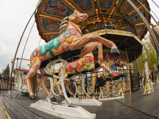 Riding around a horses carousel in autumn day