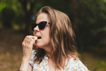 Young woman eating garlic clove outdoors