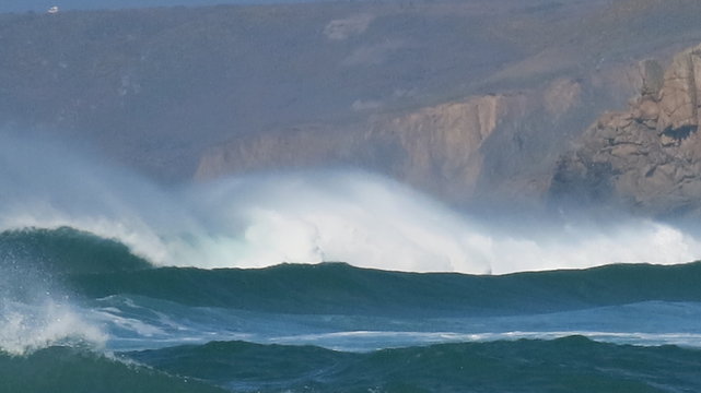 White horses riding electric blue waves at Sennen