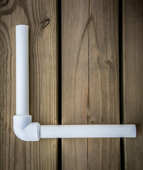 Polypropylene pvc plumbing pipes and fittings in the background of a wooden surface