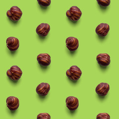 Fresh healthy tasty nutritious hazelnuts on light green background. Top view. Flat layout. Seamless pattern