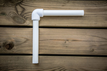 Polypropylene pvc plumbing pipes and fittings in the background of a wooden surface