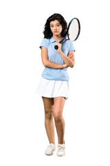 A full-length shot of a Young tennis player woman making doubts gesture while lifting the shoulders over isolated white background