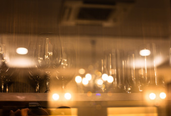 Fototapeta premium Soft focus Glass of water and a glass of wine in the mirror cabinet in Dining room prepare for party .Adjusting the image in a Luxury tone .Decorative elegant vintage and Contemporary interior Concept