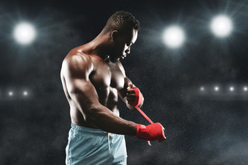 Professional boxer wrapping his fists before fight