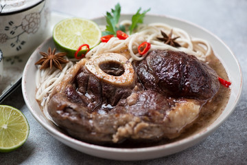 Close-up of ossobuco cooked in panasian style with udon noodles, selective focus