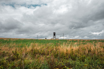 Fototapeta premium Hochsitz für Jäger auf einem weitem Feld im Herbst in Deutschland