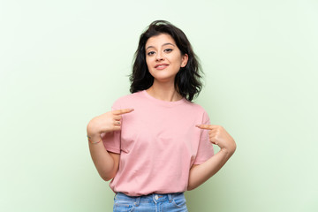 Young woman over isolated green background with surprise facial expression