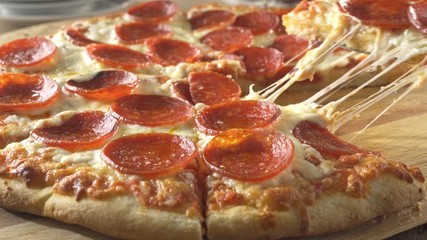 A slice of pepperoni pizza being served.