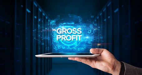Young business person working on tablet and shows the inscription: GROSS PROFIT, business concept