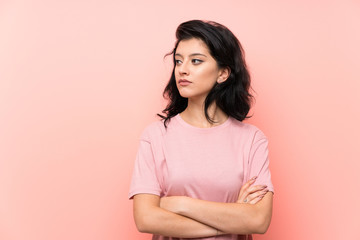 Obraz premium Young woman over isolated pink background looking side