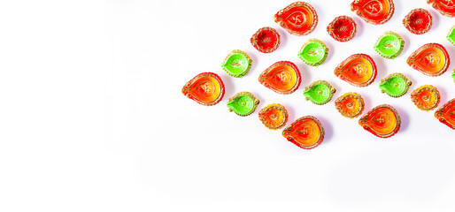 Happy Diwali, Colorful design of Clay Diya lamps lit during Dipavali festival on white background