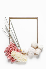 Knitting flat lay composition frame made of yarn knitting needles on a white background, creative work hobby handmade knitting