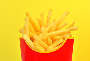 Frybox with french fries on a yellow background, close-up