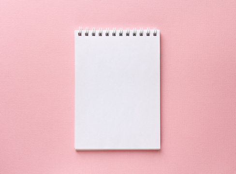 open notebook on pastel pink background