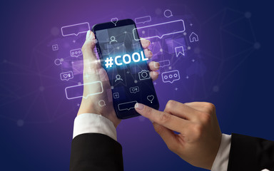 Female hand typing on smartphone with COOL inscription, social media concept