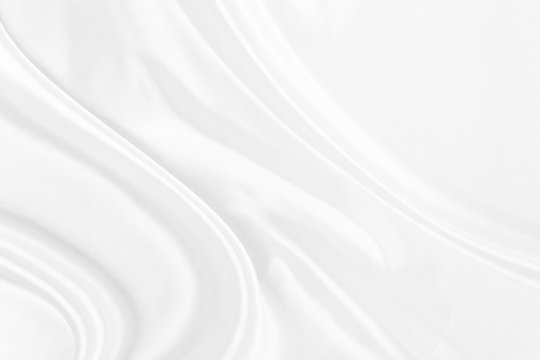 White fabric texture that is white silk background with beautiful soft blur pattern. © Kamjana
