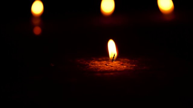 Burning candle just on the verge of being finished footage with copy space isolated on black dark background. Concept for Diwali, religious decoration,culture,grief,protest,death.