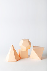 Paper geometric figures on grey background
