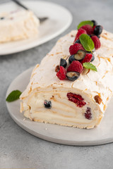 Meringue roll cake with cream and raspberries. Roulade, summer dessert, closeup.