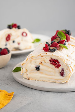 Meringue roll cake with cream and raspberries. Roulade, summer dessert, closeup.