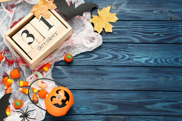 Halloween candies with wooden calendar and pumpkin bucket with candies