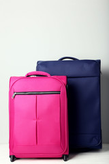Pink and blue suitcases on grey background