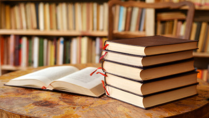 Working space with pile of books and booksehelf  background interior