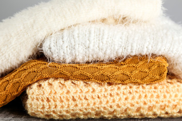 Folded sweaters on grey background