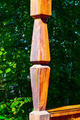 Carved element of an old wooden house in Siberia on the porch. Side view.