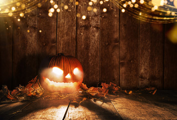 Spooky halloween pumpkin on wooden planks in dark cellar.