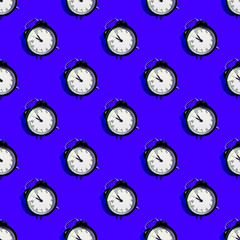 Many black classic style alarm clock with hard shadow isolated on blue background. Smile time concept. Seamless pattern