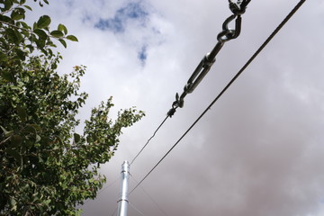 Obraz premium Tensioned cable on the hook. Clamps and tensioning cables. The tensioned cable holds the smok pipe