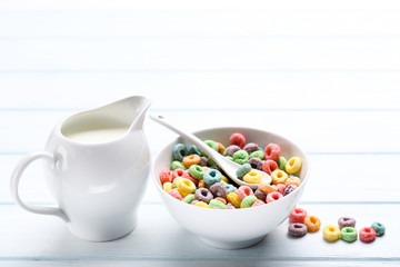 Colorful corn rings with milk in jar on wooden table
