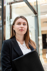 Fototapeta premium portrait of a young business woman holding documents indoors