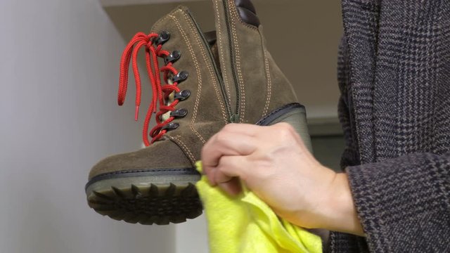 Woman cleaning her boots close up