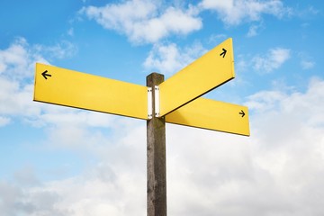 Direction signs against blue sky