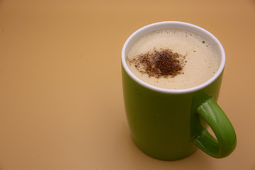 Cappuccino in a green glass
