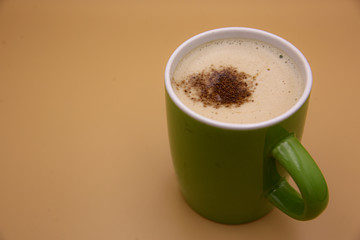 Cappuccino in a green glass