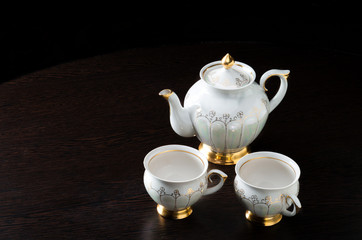 Elegant white tea set on dark background