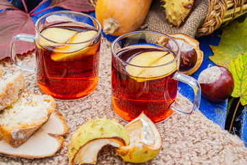 Autumn picnic in the old Park with hot tea and cake. Autumn background pumpkin, chestnuts, apples in a basket and maple leaves.Autumn vacation.