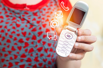 closeup woman hand using classic ancient clapet phone with icon mobile phone, mail, telephone and...
