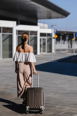 girl with a suitcase travels. Looking for a bus at the station.