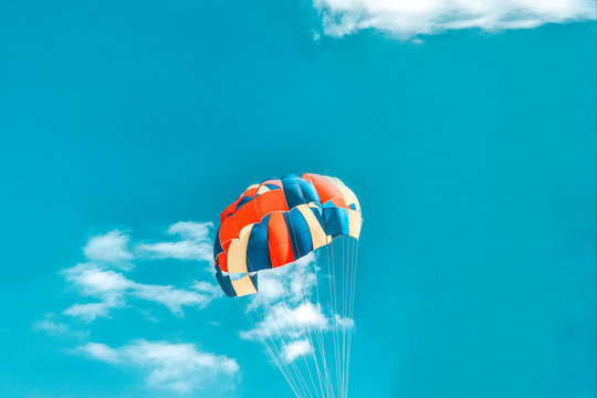 A multi-colored dome of a parachute in the sky as a background.
