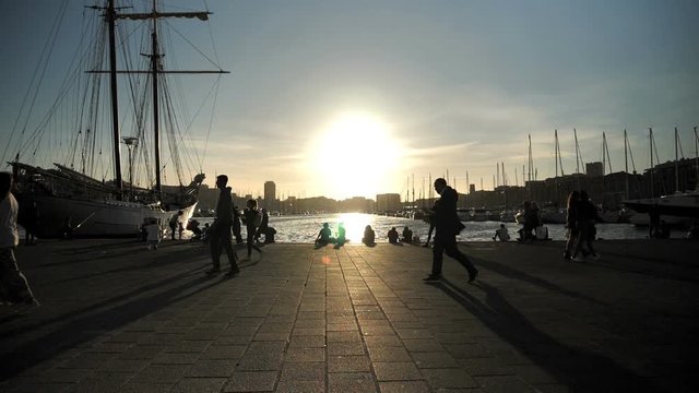 MARSEILLE, FRANCE - SEPTEMBER 28, 2019: At sunset people walk along the old port of Marseille, France