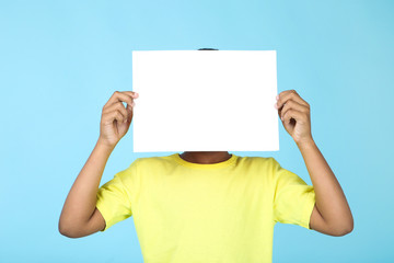 American boy with blank board on blue background
