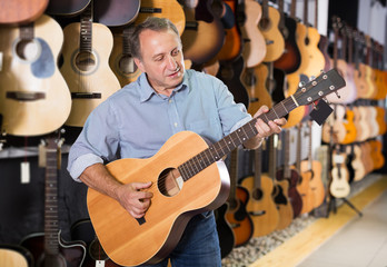 Obraz premium Man is playing on acoustic guitar