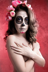 Young half-naked girl in a wreath of flowers. Girl skeleton. Sugar skull of dead bride on red background,  on her head a wreath of peonies