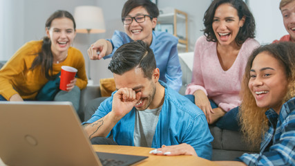 Diverse Group of Friends Use Laptop in the Living Room. Happy Beautiful Girls and Guys Live Streaming or Watching Content. They Have Fun and Laugh.