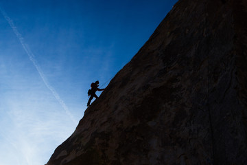 Silhouette of a mountain climber up a mountain